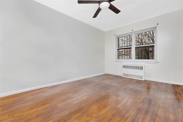 unfurnished room featuring radiator, dark wood-type flooring, and ceiling fan