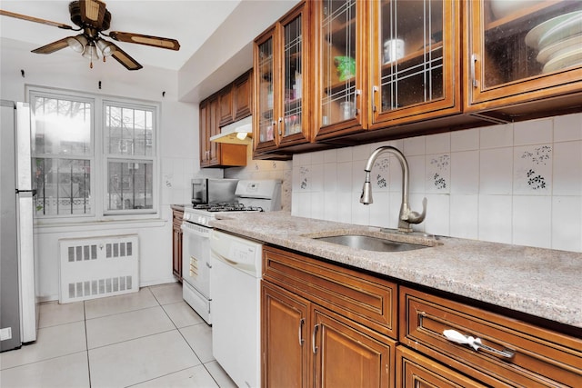 kitchen featuring radiator, white appliances, ceiling fan, sink, and light tile patterned flooring