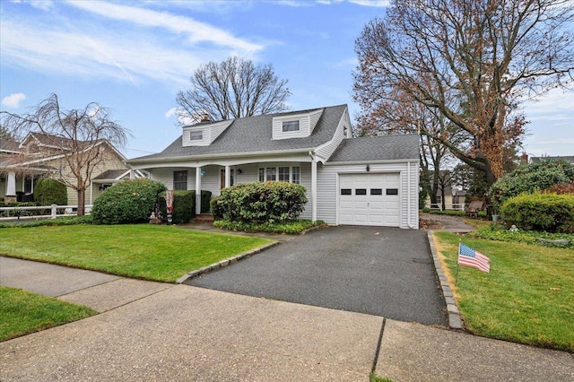 cape cod house featuring a garage and a front lawn