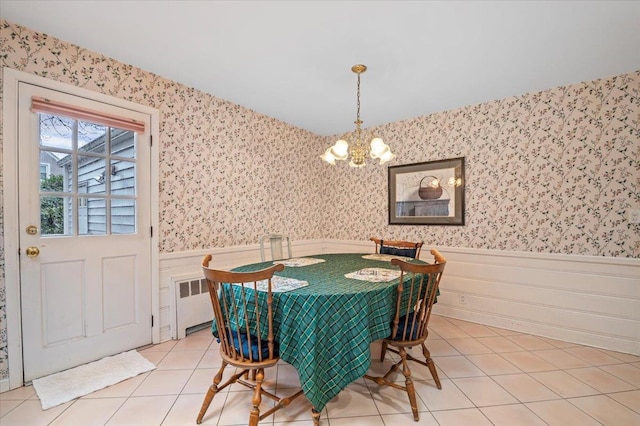 dining space featuring light tile patterned floors, radiator, and a notable chandelier