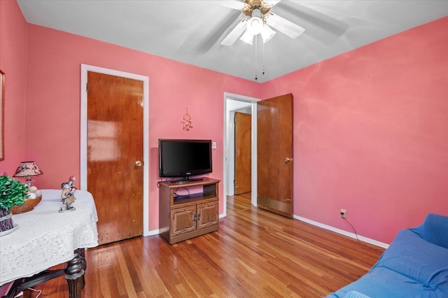 living room with ceiling fan and wood-type flooring