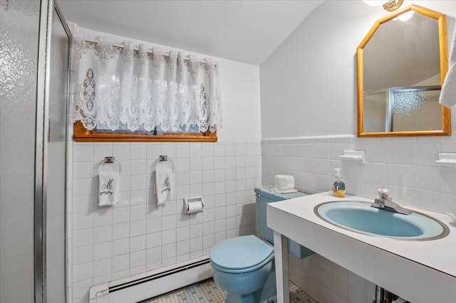 bathroom featuring toilet, tile walls, baseboard heating, and sink