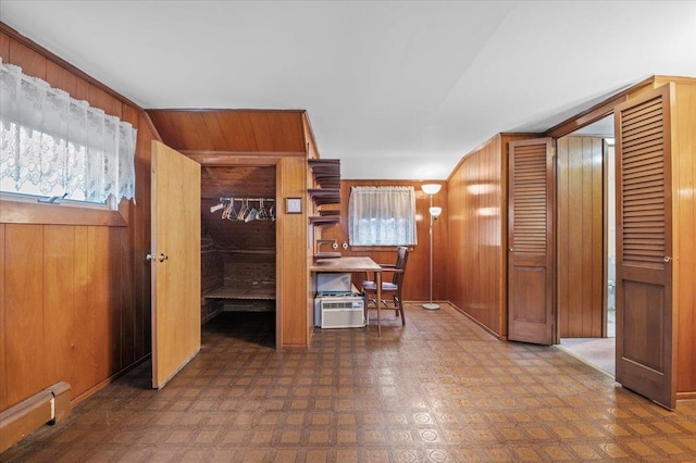 interior space with a wall unit AC, wooden walls, and a baseboard heating unit