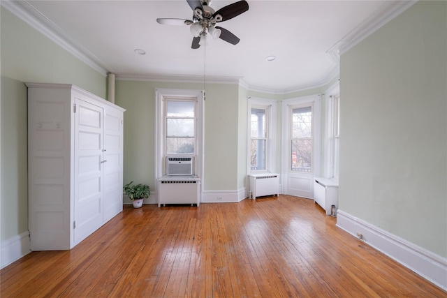 unfurnished bedroom with light hardwood / wood-style floors, radiator, ornamental molding, and ceiling fan