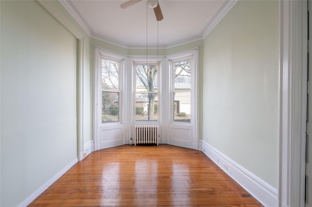 spare room with light wood-type flooring, radiator heating unit, and a wealth of natural light