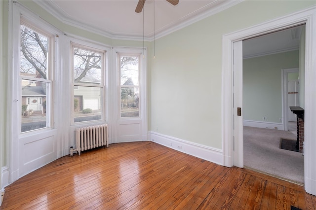 unfurnished sunroom with ceiling fan, a healthy amount of sunlight, and radiator