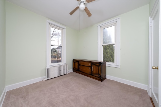 carpeted spare room with ceiling fan and radiator heating unit