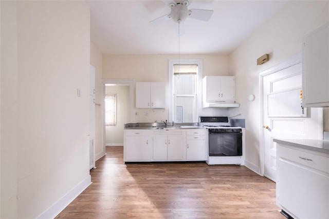 kitchen featuring ceiling fan, sink, light hardwood / wood-style flooring, white range with gas cooktop, and white cabinets