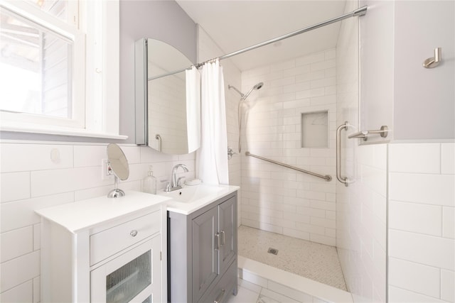 bathroom featuring a shower with shower curtain, vanity, and tile walls