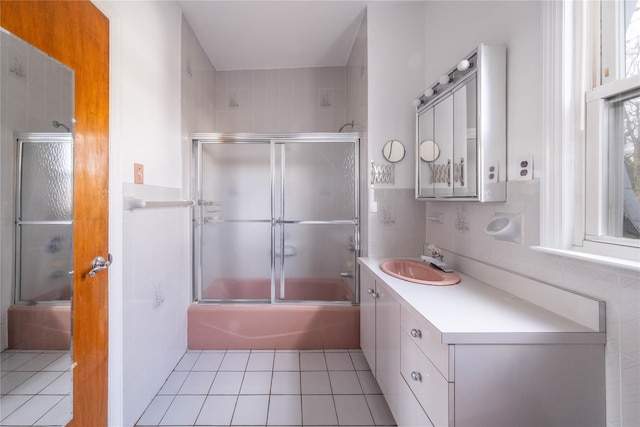 bathroom featuring tile patterned flooring, vanity, and bath / shower combo with glass door