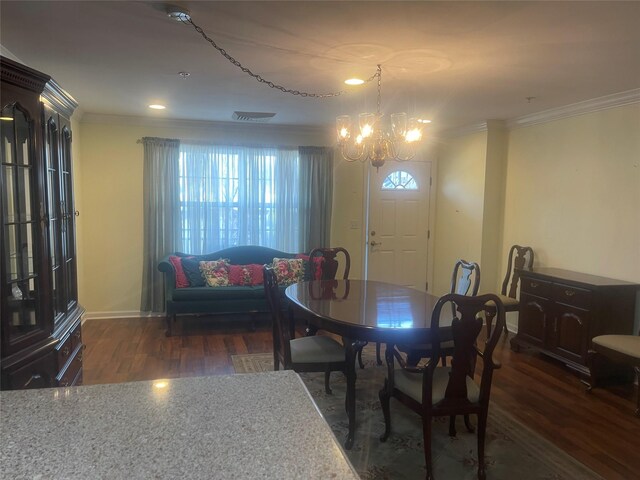 dining room with baseboards, a chandelier, crown molding, and wood finished floors