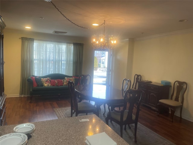 dining space featuring a chandelier, wood finished floors, visible vents, and crown molding