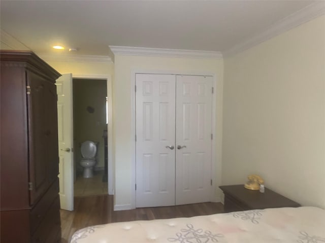 bedroom with ensuite bath, a closet, wood finished floors, and crown molding