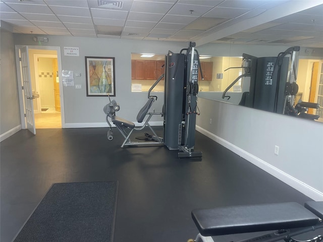 workout area with a drop ceiling and baseboards