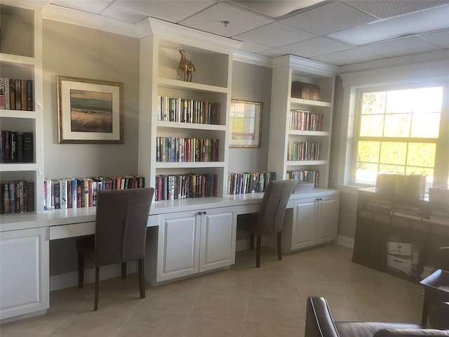 office space with light tile patterned floors, built in shelves, built in study area, and ornamental molding