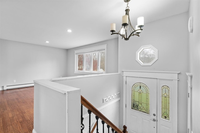 foyer entrance with dark hardwood / wood-style floors, an inviting chandelier, and baseboard heating