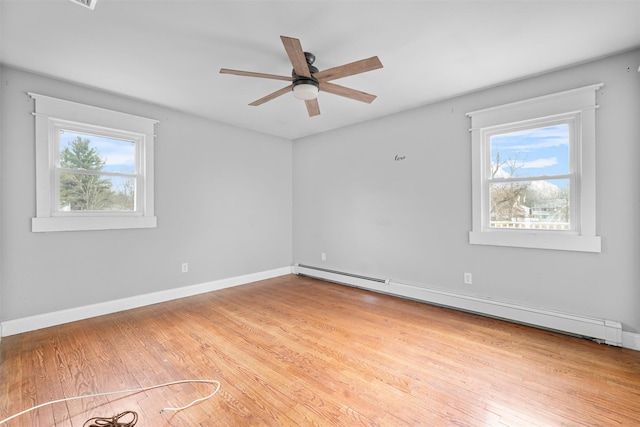 unfurnished room with ceiling fan, light wood-type flooring, baseboard heating, and a wealth of natural light