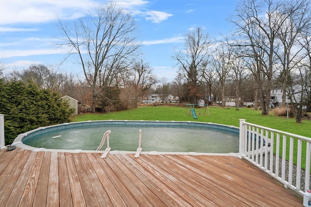 view of swimming pool with a yard and a deck