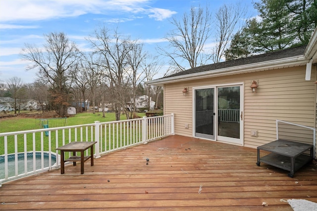 wooden deck with a lawn and a swimming pool