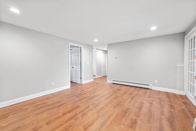 empty room featuring light hardwood / wood-style floors and a baseboard heating unit