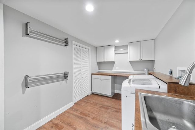 kitchen featuring light wood-type flooring, white cabinetry, and sink