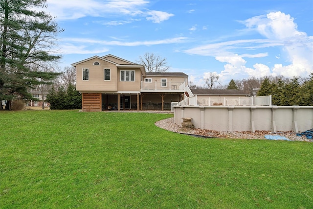 rear view of house featuring a lawn and a pool side deck