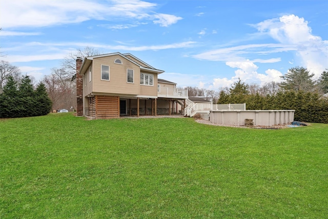 back of house featuring a pool side deck and a yard