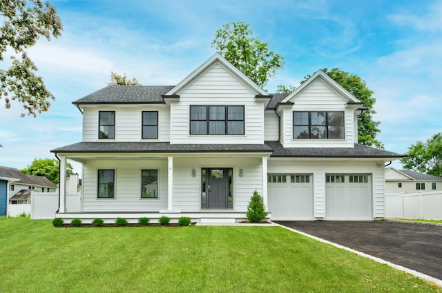 view of front of house with a porch, a garage, and a front lawn