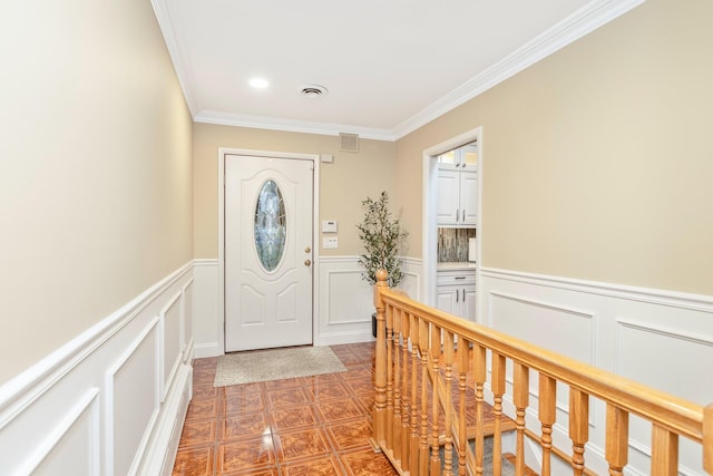 foyer entrance featuring ornamental molding and dark tile patterned floors