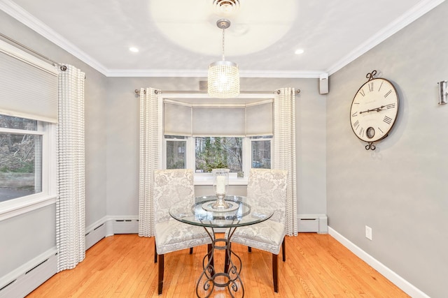 dining area with baseboard heating, ornamental molding, and hardwood / wood-style flooring