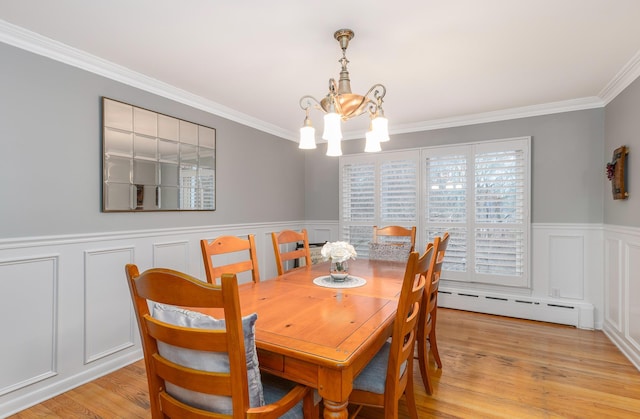 dining room featuring an inviting chandelier, ornamental molding, light hardwood / wood-style flooring, and a baseboard heating unit