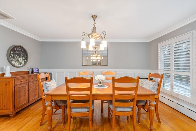 dining space with ornamental molding, an inviting chandelier, baseboard heating, and light hardwood / wood-style floors