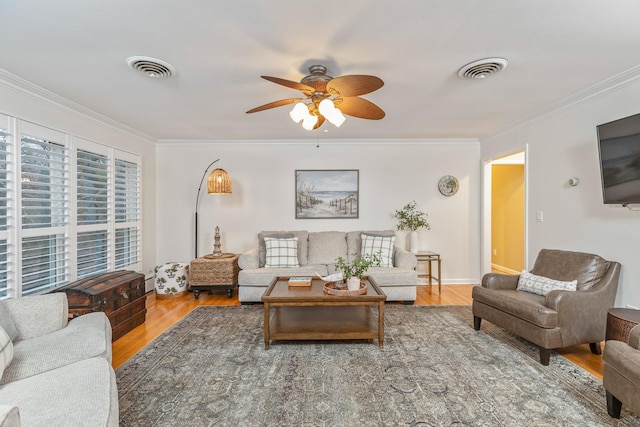 living room featuring hardwood / wood-style flooring, ceiling fan, and ornamental molding