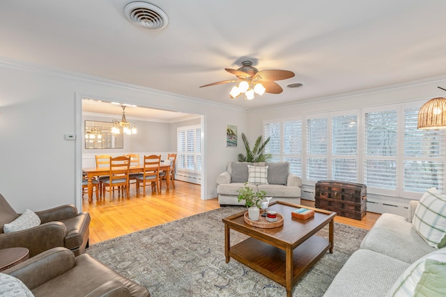 living room with hardwood / wood-style flooring, ornamental molding, ceiling fan with notable chandelier, and baseboard heating