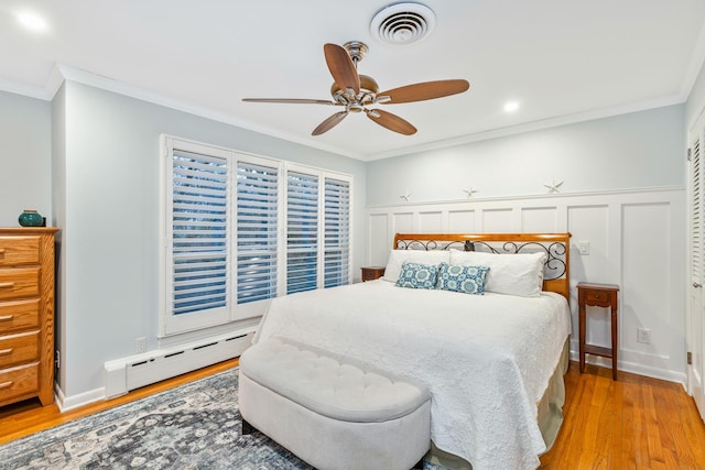 bedroom featuring ceiling fan, a baseboard radiator, ornamental molding, and light hardwood / wood-style flooring