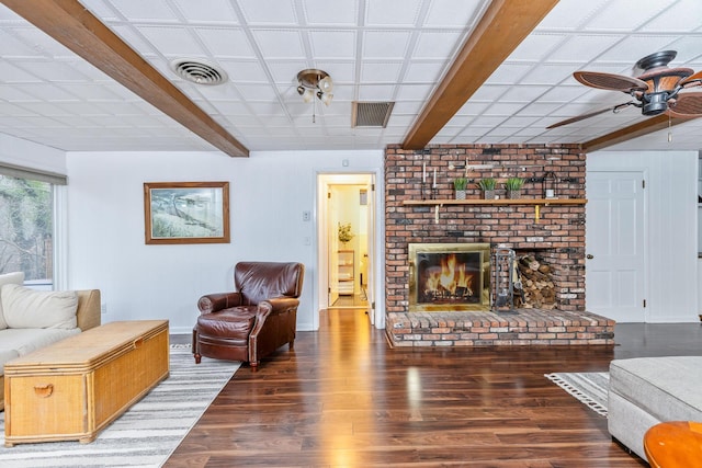 living room featuring a brick fireplace, dark hardwood / wood-style floors, and ceiling fan