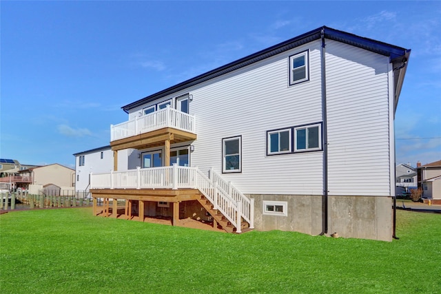 rear view of house with a lawn, a wooden deck, and a balcony