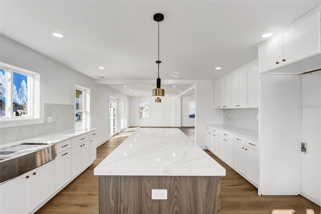 kitchen featuring a center island, white cabinets, and hanging light fixtures