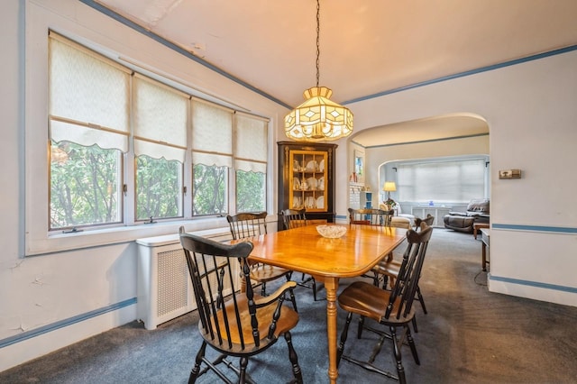 carpeted dining room featuring crown molding