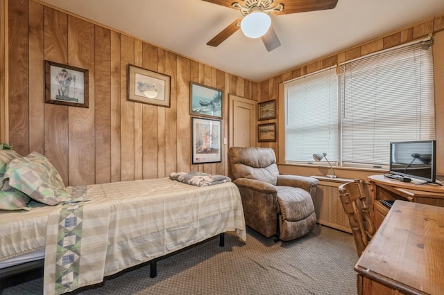 bedroom featuring carpet flooring, ceiling fan, and wood walls