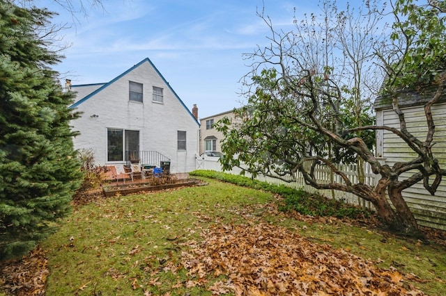 back of property with a lawn and a deck