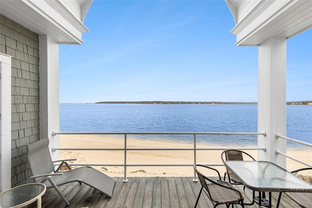 balcony featuring a view of the beach, french doors, and a water view