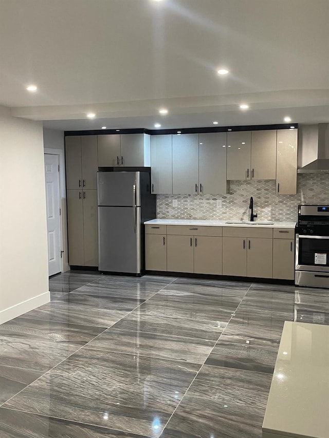 kitchen featuring gray cabinetry, wall chimney exhaust hood, sink, and stainless steel appliances