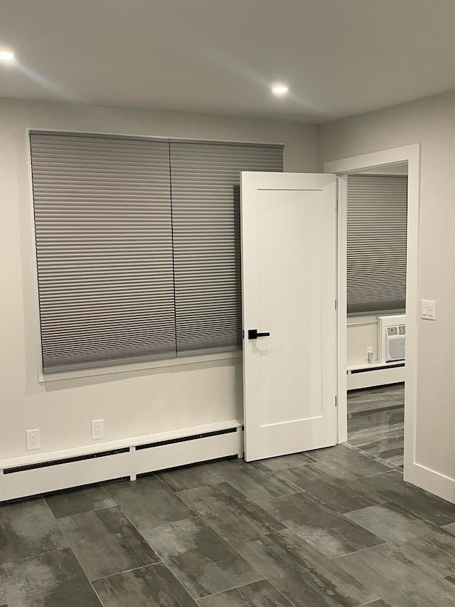 closet featuring a wall mounted air conditioner and baseboard heating