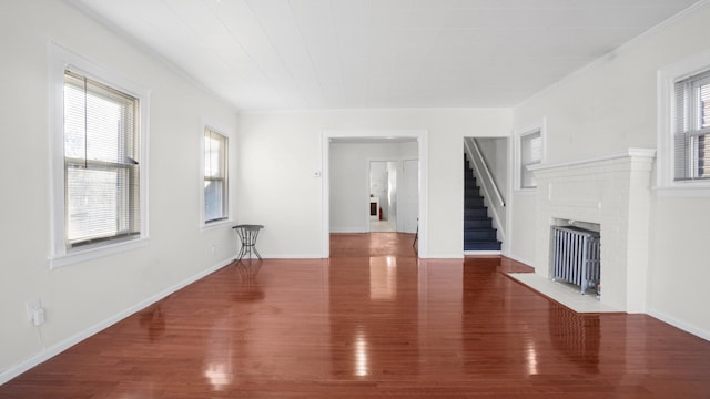 unfurnished living room with radiator, a fireplace, dark hardwood / wood-style floors, and ornamental molding