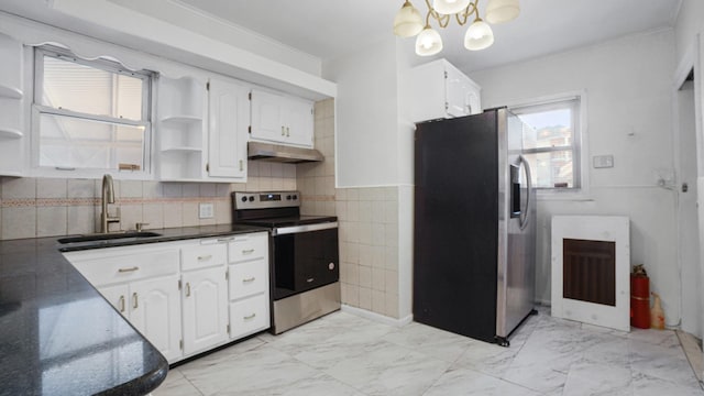 kitchen featuring white cabinets, appliances with stainless steel finishes, a chandelier, and sink