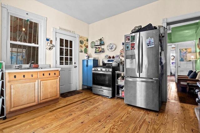 kitchen featuring appliances with stainless steel finishes, light hardwood / wood-style floors, light brown cabinetry, and sink