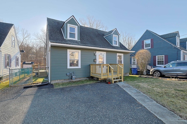 cape cod-style house featuring a front lawn