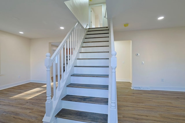 staircase with hardwood / wood-style floors