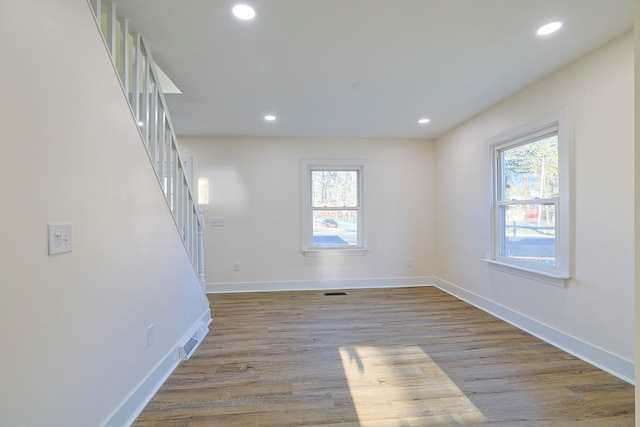 empty room with a healthy amount of sunlight and light hardwood / wood-style floors